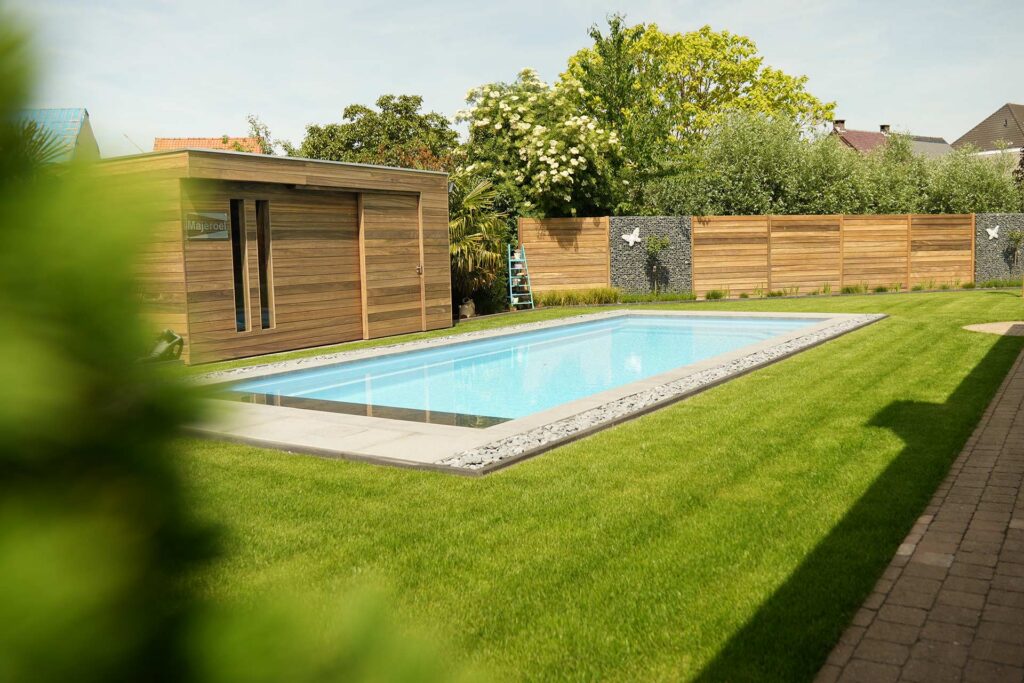 Zwembad in moderne tuin met groene graszone en terras
