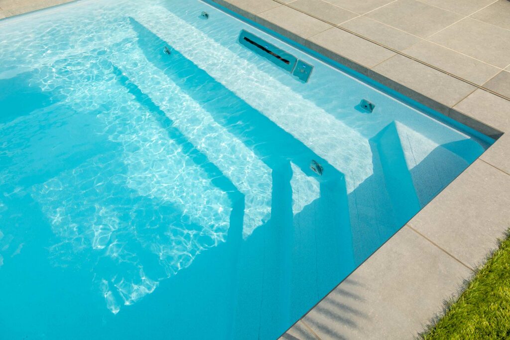 Zwembad in moderne tuin met groene graszone en terras