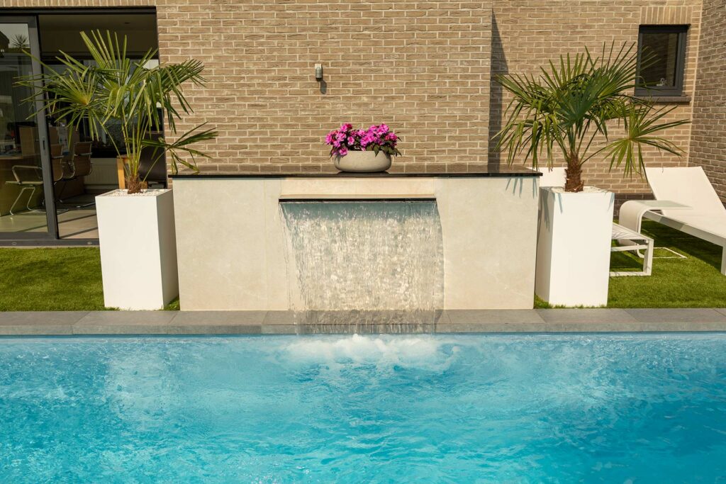 Zwembad naast moderne woning met grijs terras en palmboom